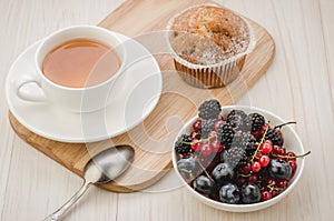 healthy breakfast: tea and  with fresh berries/healthy breakfast: tea and  with fresh berries on a light wooden background