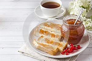 Healthy Breakfast with toast, jam and red currants, a Cup of coffee on the white table.