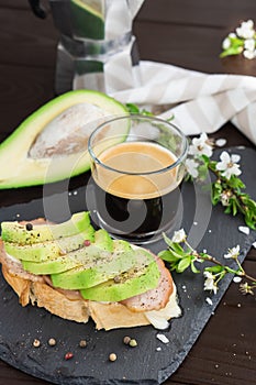 Healthy breakfast. Toasted grain bread with fresh sliced avocado, ham, cheese and cup of coffee