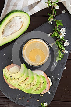 Healthy breakfast. Toasted grain bread with fresh sliced avocado, ham, cheese and cup of coffee