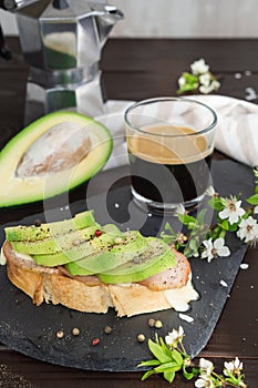 Healthy breakfast. Toasted grain bread with fresh sliced avocado, ham, cheese and cup of coffee