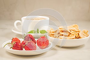 healthy breakfast on a white table/breakfast with strawberry, flakes, honey and tea with mint on a white background. Selective