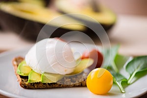 Healthy breakfast with wholemeal toast and benedict eggs with green salad and avocado