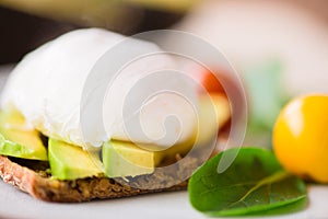 Healthy breakfast with wholemeal toast and benedict eggs with green salad and avocado