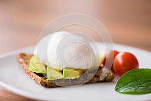 Healthy breakfast with wholemeal toast and benedict eggs with green salad and avocado