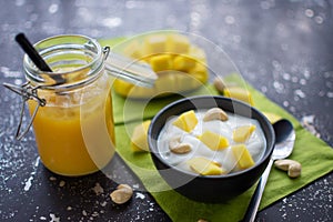 Healthy breakfast of yoghurt with cashew nuts and fresh mango pieces.