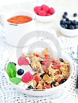 Healthy breakfast, yogurt with granola and berries on the white table