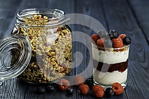 The healthy breakfast of yogurt with muesli, granola raspberry jam and fresh fruits raspberry and blueberry