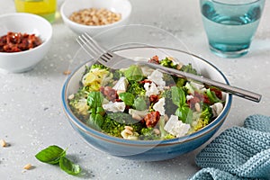 healthy broccoli salad with feta cheese sun dried tomatoes pine nuts.. vegetarian low carb keto diet photo