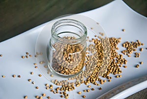 Healthy buckwheat grains in glass jar on white plate