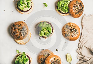 Healthy burgers with beetroot patties, avocado cream and green sprouts