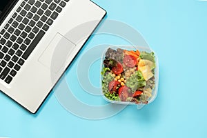 Healthy business lunch in the office, salad for snack on blue table. Top view with copy space. Concept proper nutrition. Take away