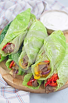 Healthy cabbage leaves wraps with beef, vegetables and cheese, served with plain yogurt, vertical