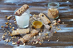 Healthy cereal bars with glass of milk on the wooden table, with copy space