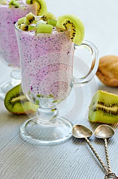 Healthy chia blueberry pudding in the glass with yogurt and fresh sliced kiwi fruit. Detox superfoods breakfast or diet dessert