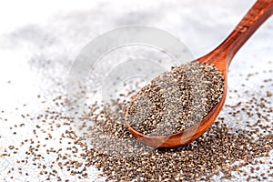 Healthy Chia seeds in a wooden spoon on the table close-up.