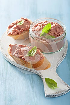 Healthy chicken liver pate with sage in jar and on bread