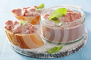 Healthy chicken liver pate with sage in jar and on bread