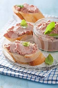 Healthy chicken liver pate with sage in jar and on bread