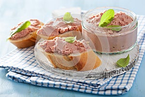 Healthy chicken liver pate with sage in jar and on bread