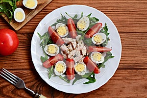 Healthy chicken vegetable salad. Homemade salad with fresh tomatoes, arugula, quail eggs, boiled chicken breast and spices