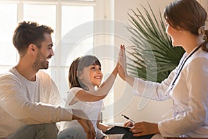 Healthy child girl giving high five to doctor celebrate recovery