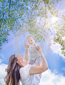 Healthy child (kid) having fun with mother in the sunny summer day at the park. Caucasians baby (boy).