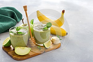 Healthy clean eating concept Glass mug with green health smoothie of apple spinach lime and honey on table with copy space
