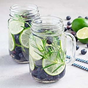 Healthy cold infused water with fresh blueberry, lime and rosemary, square photo