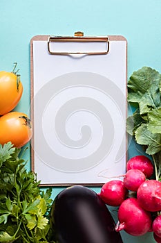 Healthy concept. Fresh vegetables around white desk on blue background. Copy space.