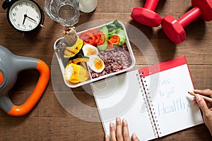 Healthy concept with nutrion food in lunch box and fitness equip photo