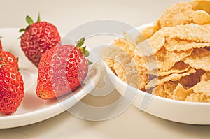 Healthy concept with strawberry and flakes/healthy concept: strawberry and flakes in white bowls closeup. Selective focus