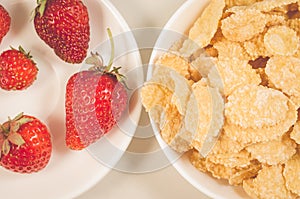 Healthy concept with strawberry and flakes/healthy concept: strawberry and flakes in white bowls closeup. Top view