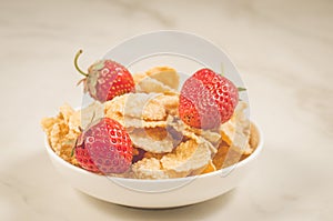 healthy concept with strawberry and flakes/healthy concept: strawberry and flakes in white bowls on a marble background. Selective