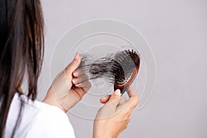 Healthy concept. Woman show her brush with damaged long loss hair and looking at her hair