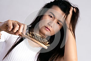 Healthy concept. Woman show her brush with damaged long loss hair and looking at her hair