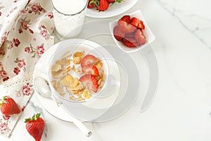 Healthy corn flakes with milk and strawberries for breakfast