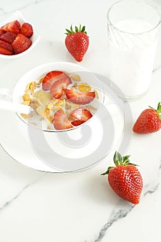 Healthy corn flakes with milk and strawberries for breakfast