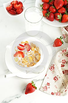 Healthy corn flakes with milk and strawberries for breakfast