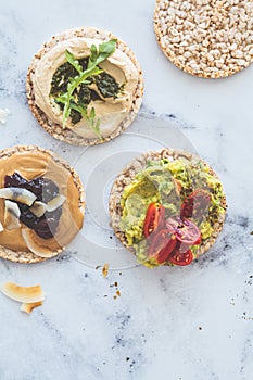 Healthy crispbread toast with avocado, peanut butter and hummus