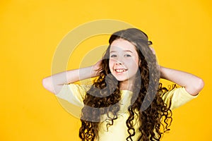Healthy curls. Easy hairdo. Beauty supplies. Perfectly untangle curly hair. Pretty girl curly hair yellow background