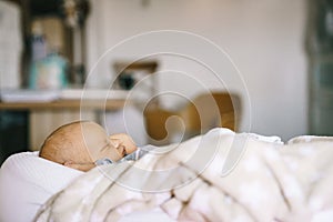 Healthy daytime sleep for the newborn. A baby in a baby cocoon sleeps in a room