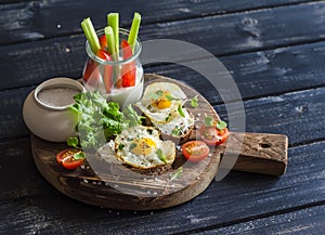 Healthy delicious breakfast or snack - sandwich with cheese and a fried quail egg, greek yogurt, celery and sweet peppers