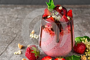 Healthy delicious breakfast. strawberry chia seed pudding with chocolate, fresh berries, granola, elderflowers and mint