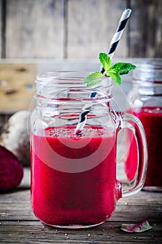 Healthy detox beet smoothie with chia seeds in a mason jar on a wooden background