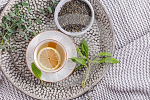 Healthy detox ginger and sage tea with lemon on tray