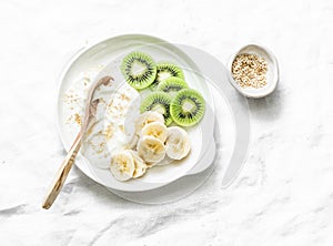 Healthy diet breakfast - greek yogurt with honey and fruit on a light background, top view