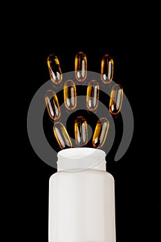 Healthy diet concept. Fish oil capsules with omega 3 and vitamin D in a plastic bottle on a black background.