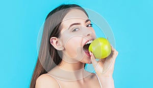 Healthy diet food. Stomatology concept. Woman with perfect smile holding apple, blue background