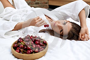 Healthy Diet Food For Woman's Health. Girl Eating Fruits On Bed